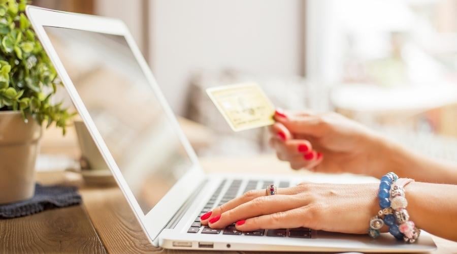 Person paying by credit card on laptop