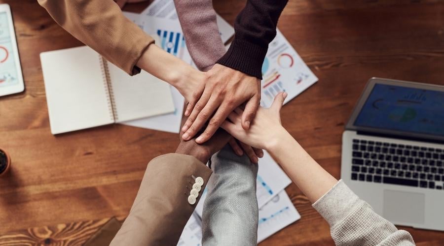 Group of people putting hand in for a handshake