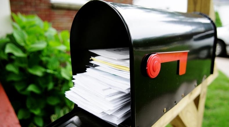 black mailbox packed with different types of mail